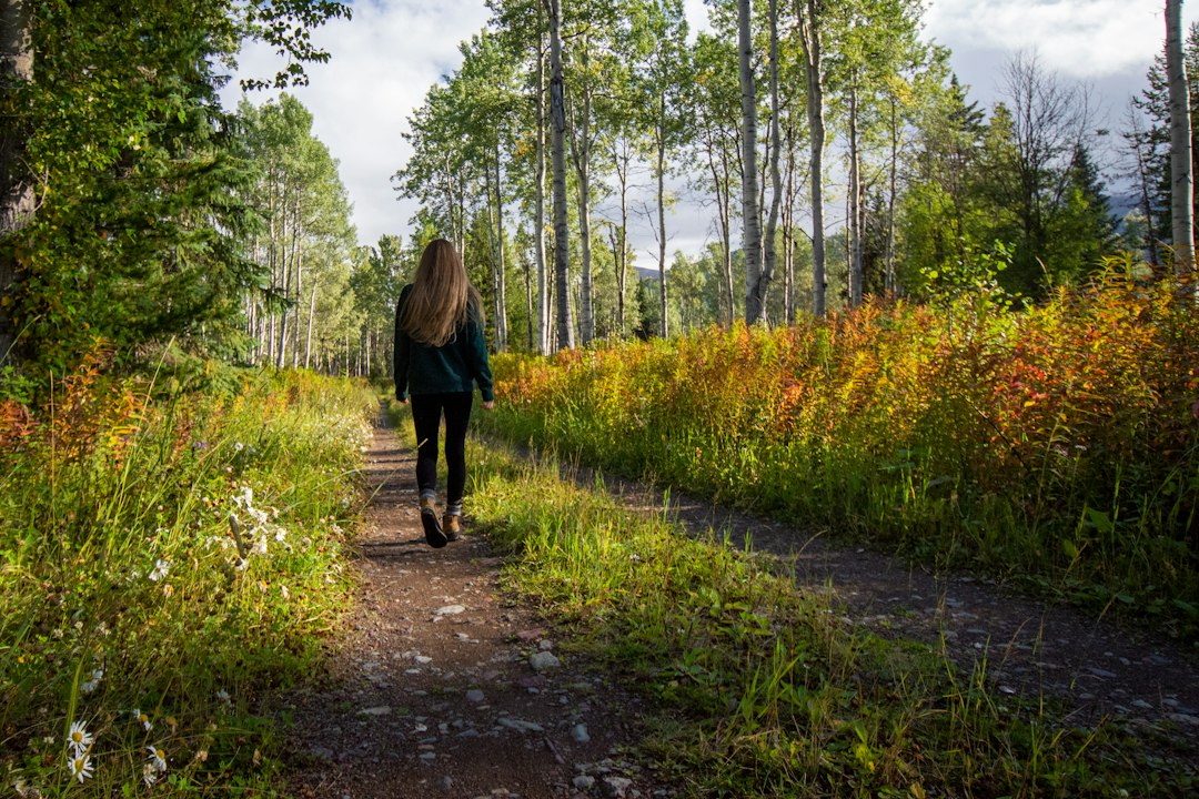 Personne marchant sur un sentier, exemple d’activité physique douce et progressive